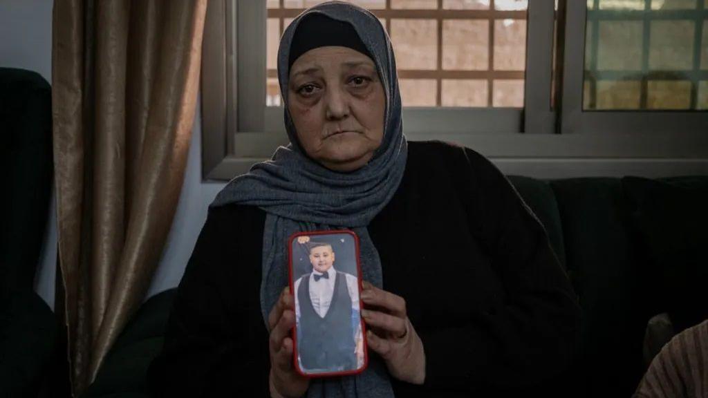 Rawia, a mãe de Rami, com uma foto do filho