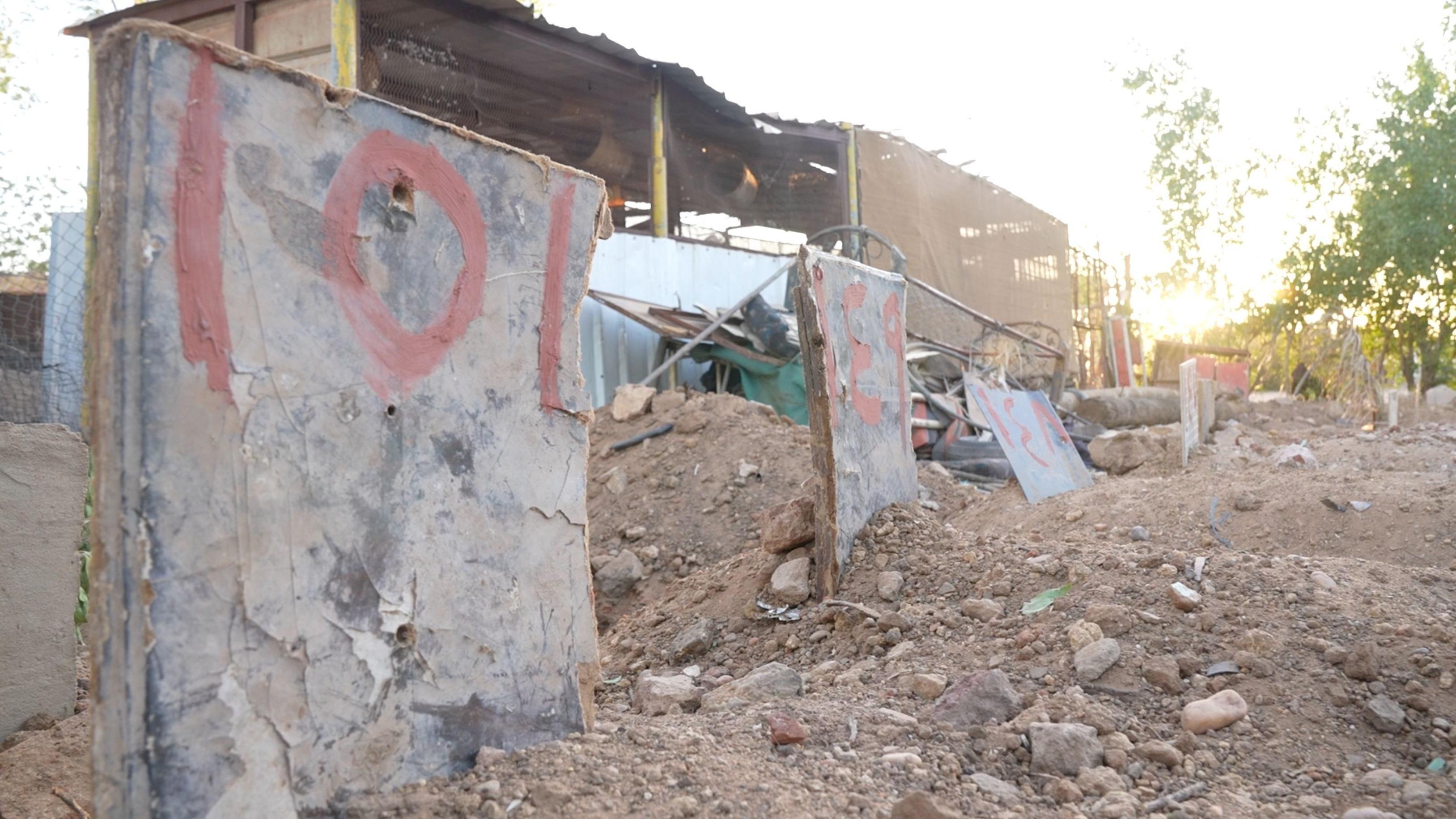3-	الحجارة والألواح عليها أرقام على مواقع الدفن على قطعة أرض بالقرب من مسجد في أم درمان