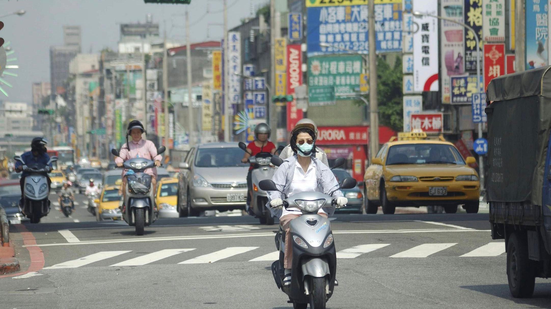 台灣機車在馬路上行駛。