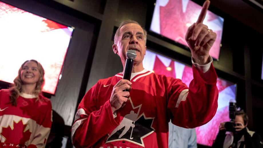 Mark Carney con una camiseta de hockey de Canadá.