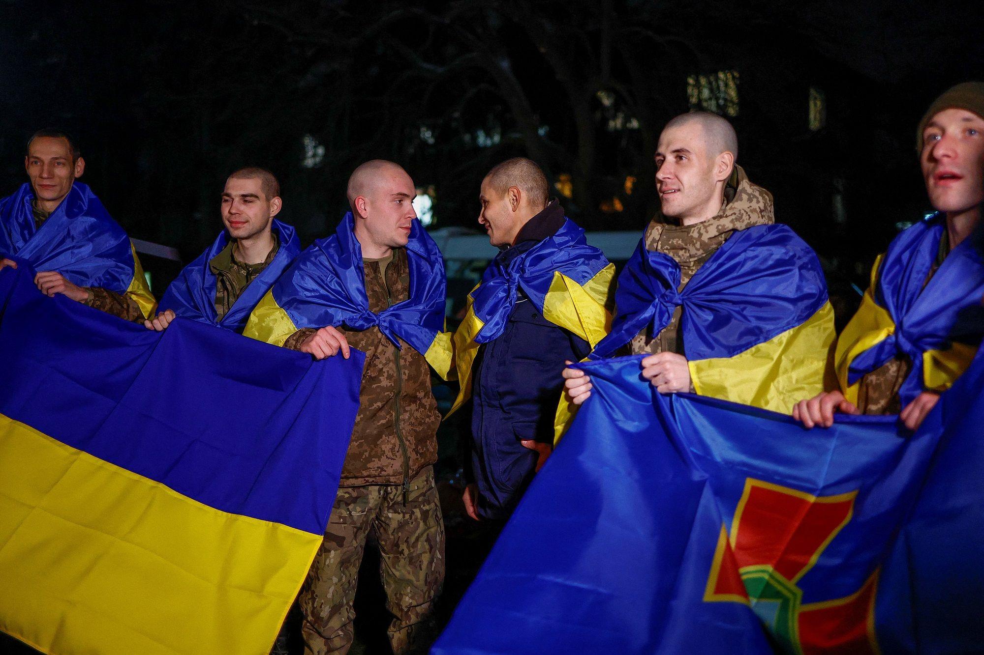 Ukrajinski vojnici zaogrnuti zastavama zemlje nakon što su razmenjeni