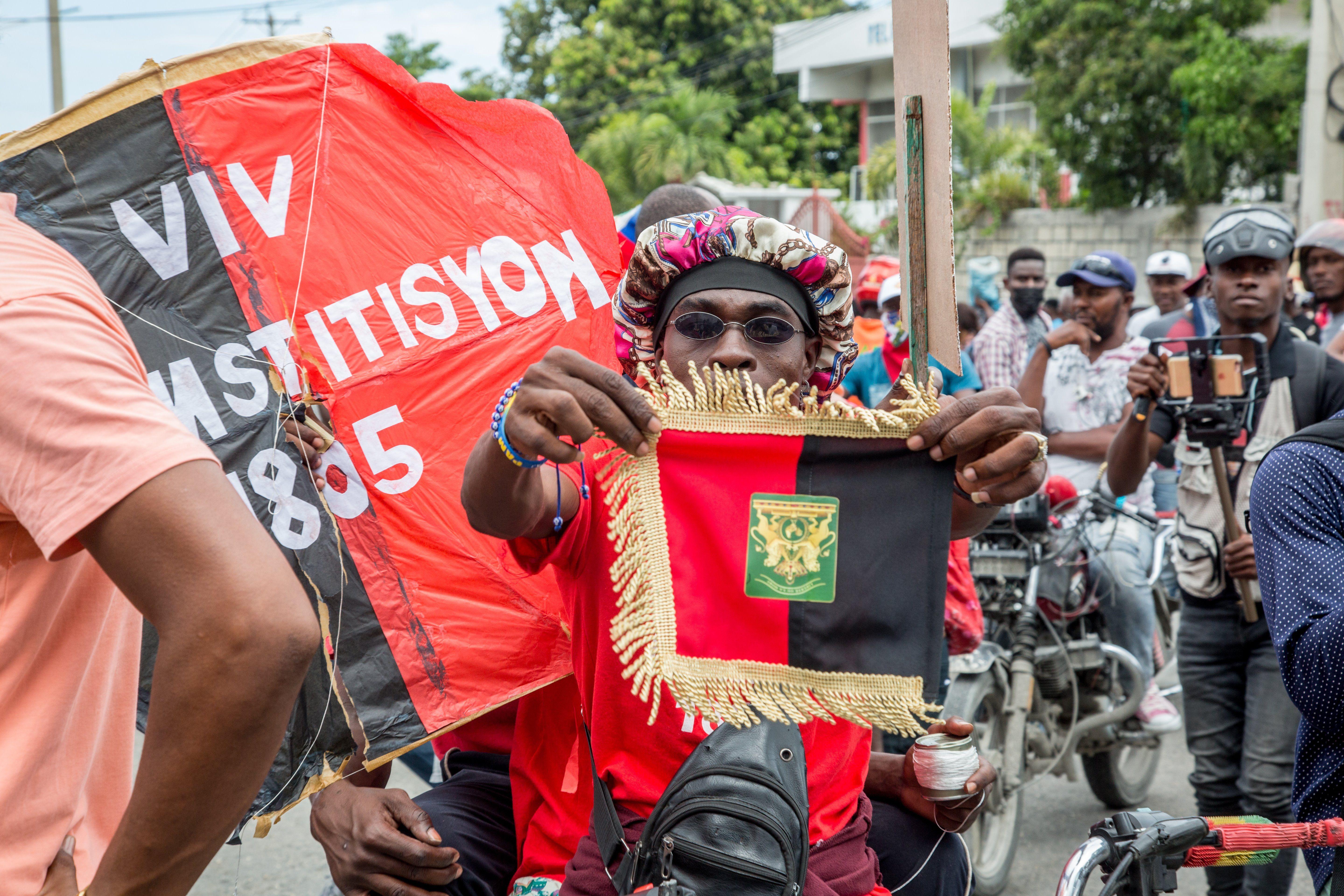 Manifestantes en Haití con una pancarta que nombra la Constitución de 1805