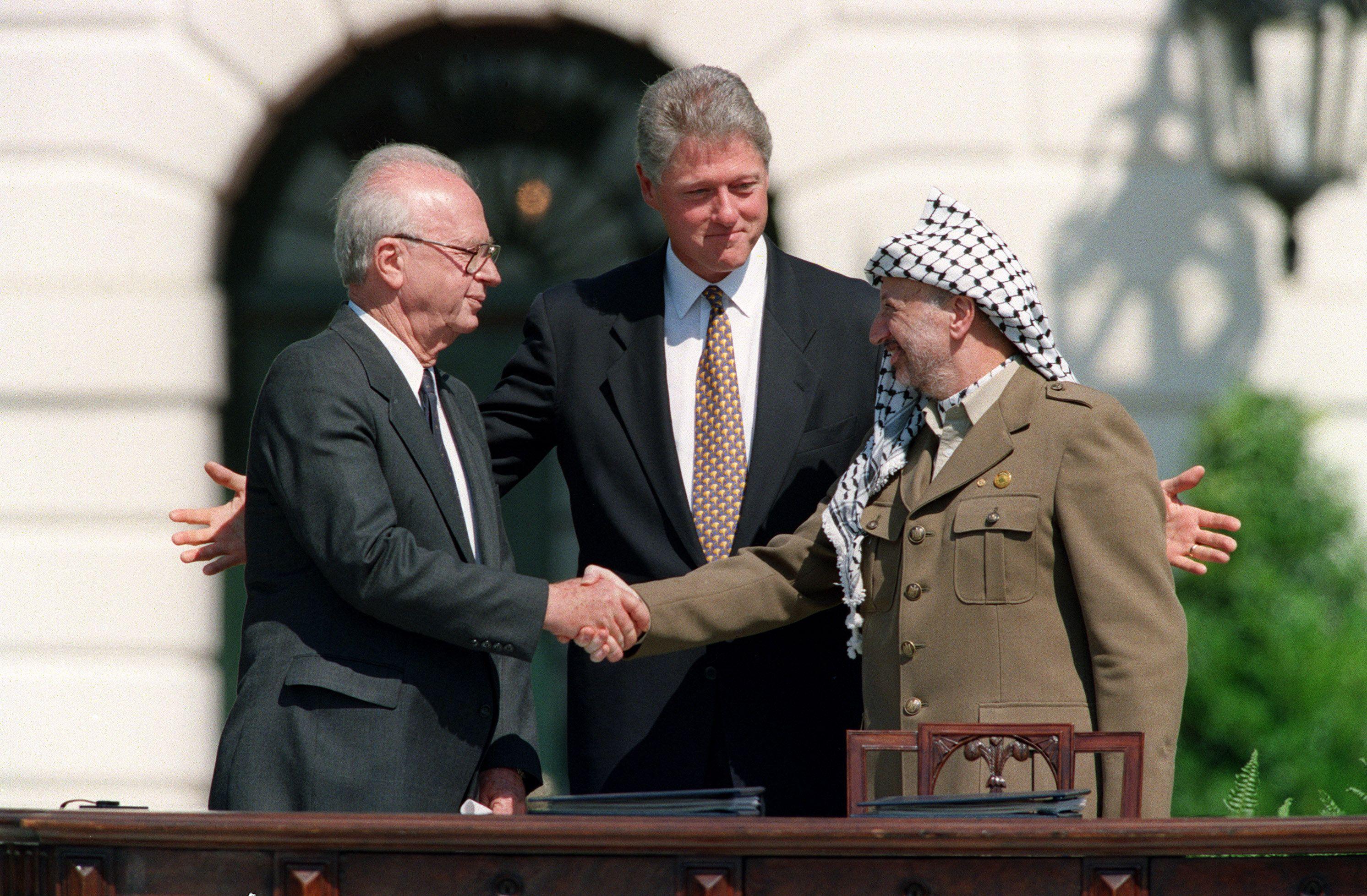 Yasser Arafat berjabat tangan dengan PM Yitzhak Rabin setelah menandatangani Kesepakatan Oslo pada 1993.