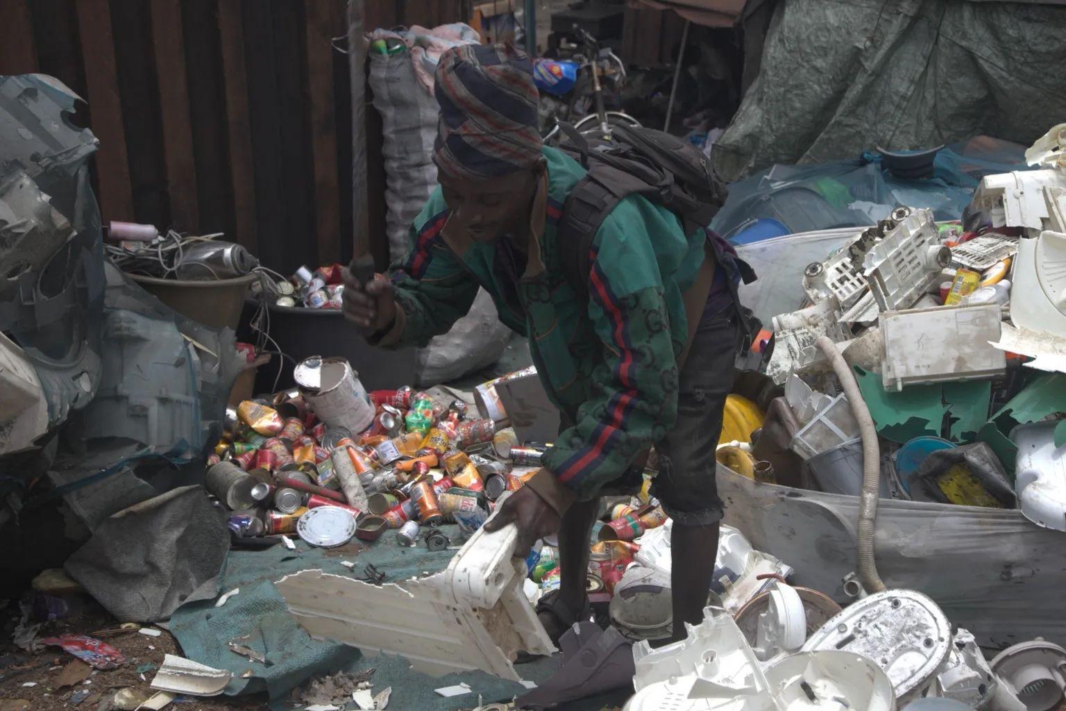 Un hombre está en medio de la basura recogiendo deshechos