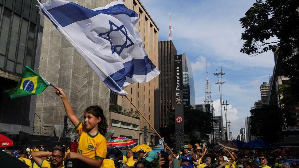 Manifestante segurando bandeira de Israel