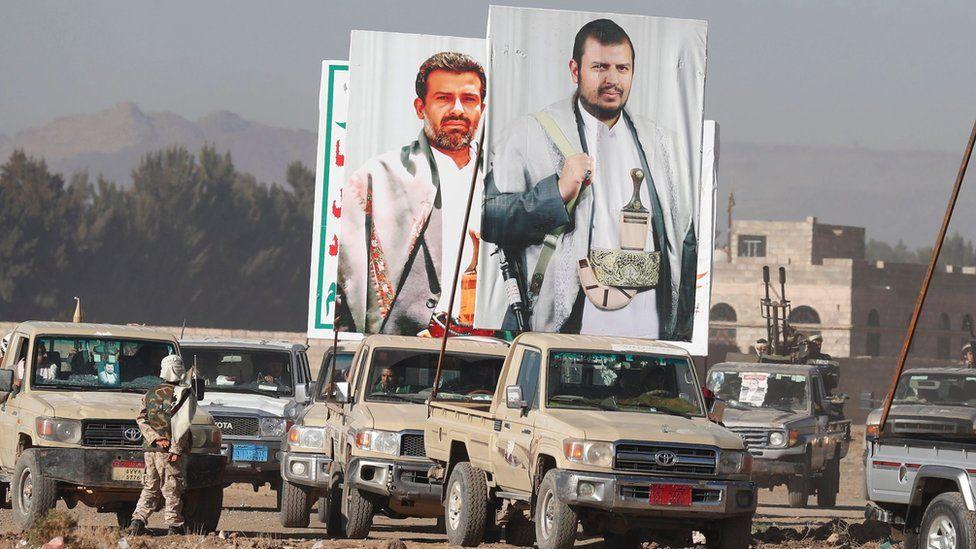 Sebuah truk pick-up membawa spanduk besar yang menggambarkan pemimpin tertinggi Houthi, Abdul-Malik Al-Houthi (kanan) saat protes anti-AS dan anti-Israel, di pinggiran Sanaa, Yaman, pada 25 Januari 2024