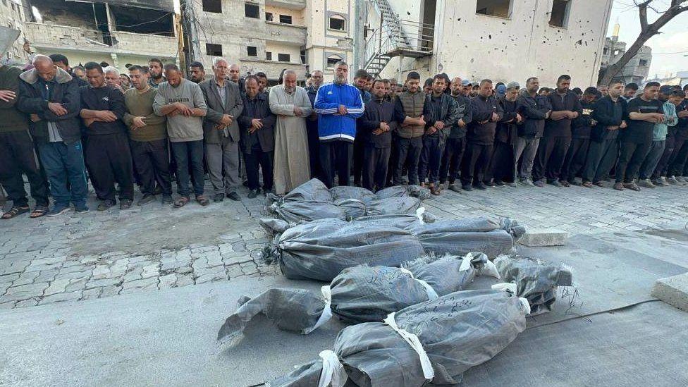 Hamas leader Ismail Haniyeh stands before the dead bodies of his three sons, along with of his two grandchildren, as people perform funeral prayers in Gaza City, Gaza, on 10 April 2024 (Photo by Ayman Alhesi/Anadolu via Getty Images)