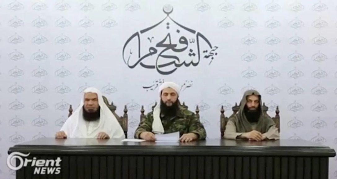 الجولاني يلقي كلمة إلى جانب مقاتلين اثنين