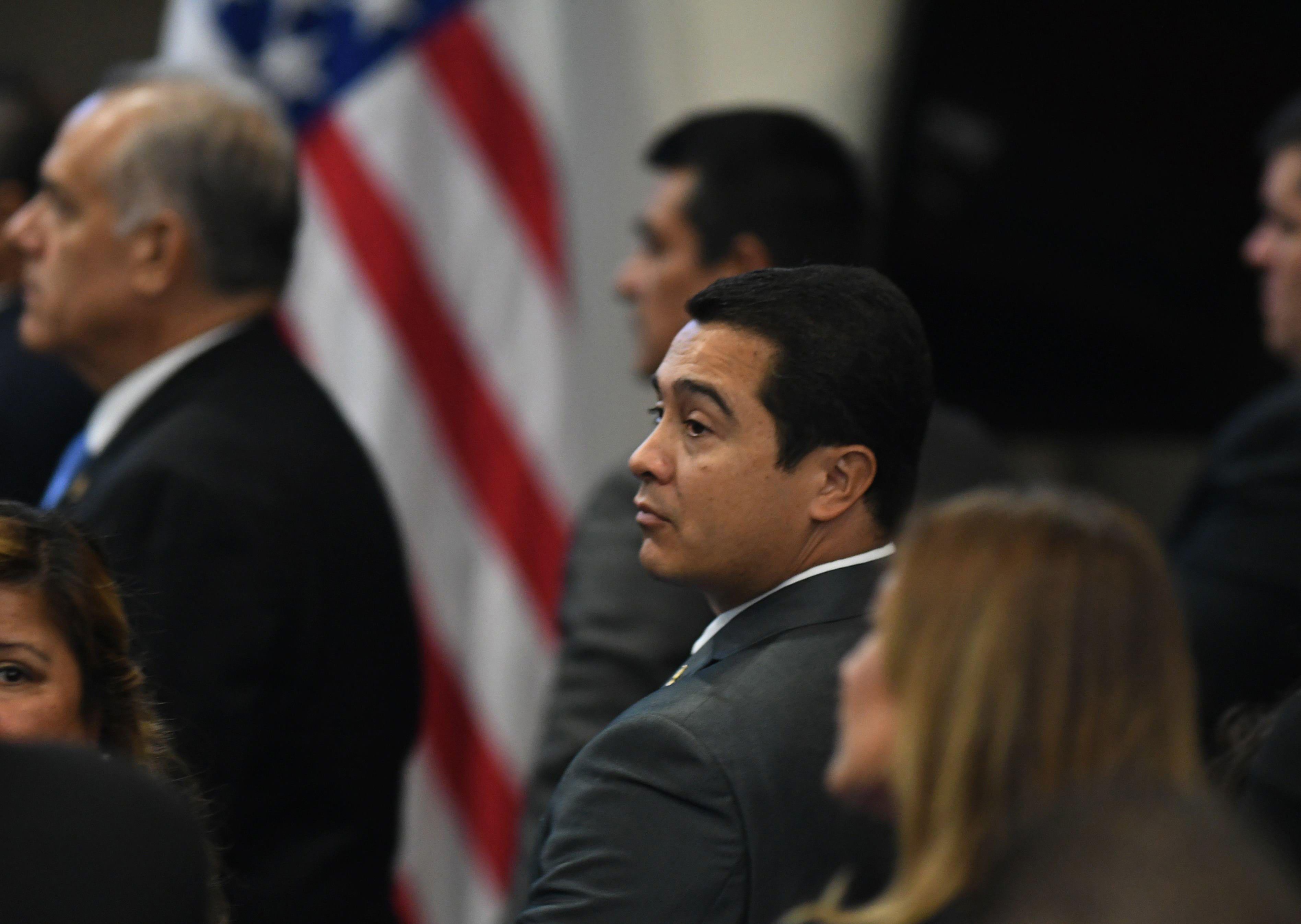 El exdiputado hondureño Tony Hernández, condenado a cadena perpetua en EE.UU., rodeado de personas frente a la bandera de EE.UU.