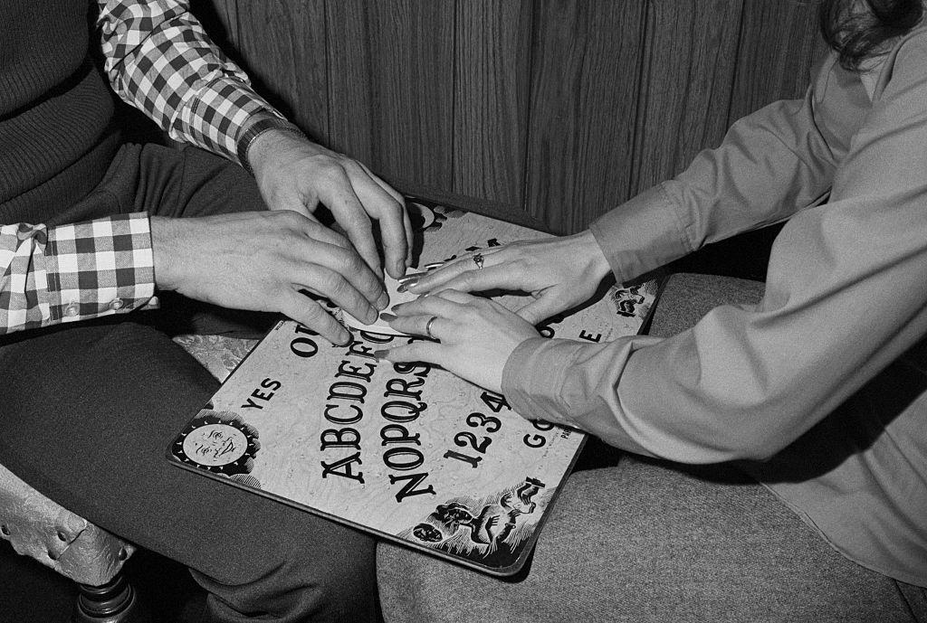 Unas personas usando una tabla Ouija