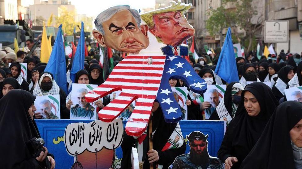 متظاهرون إيرانيون يحملون دمى لكل من ترامب ونتنياهو
