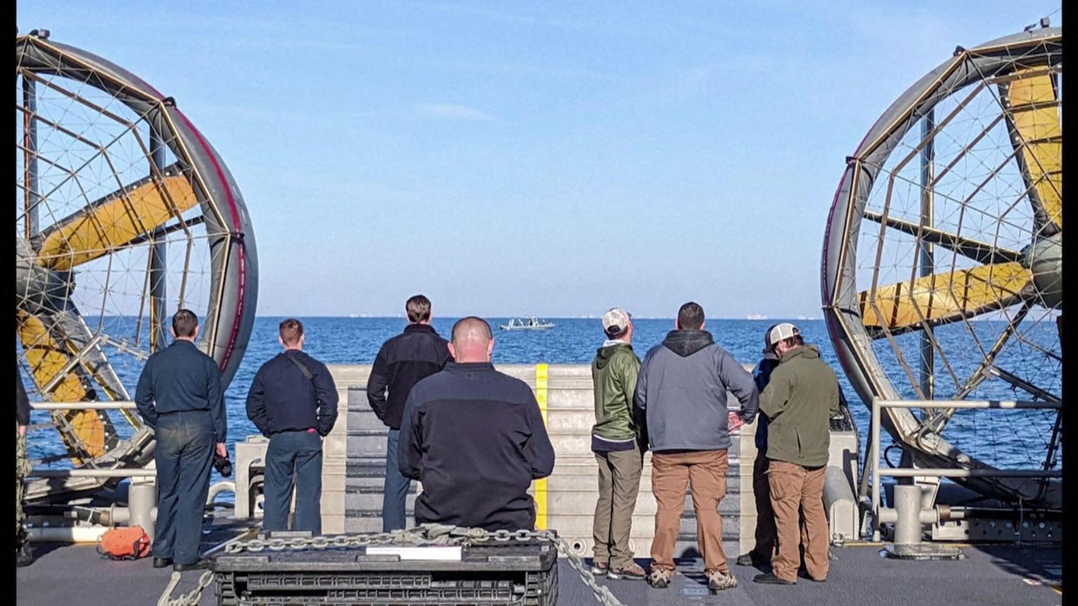 Pessoas em barco observando o mar 