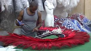 Algunos dicen que el carnaval también es una forma de generar actividad económica. Un hombre confecciona un disfraz de carnaval en Río de Janeiro.