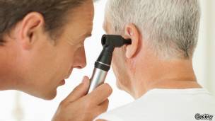 Un doctor examina el oido de un paciente.