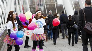 Chicas vestidas de colores reparten globos