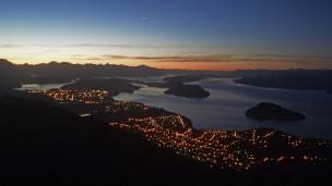 Vista panorámica nocturna de Bariloche y el lago Nahuel Huapi.