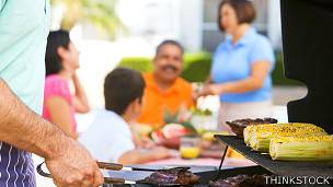 Familia en un jardín disfrutando una parrillada