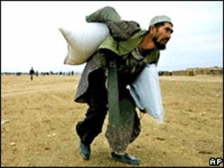 مرد افغان در حال حمل کیسه گندم