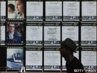 Hombre pasa delante de agencia de empleo en el Reino Unido