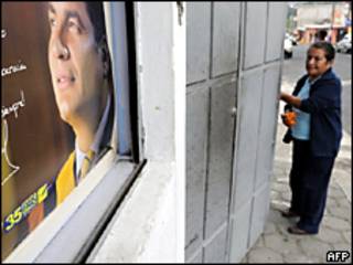 Una mujer se para frente a un póster del presidente Rafael Correa, en Quito