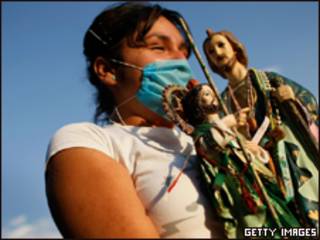 Mexicana com máscara para evitar contágio segura imagens religiosas (Getty Images, 28/4)