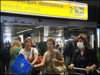 Mulher usando máscara desembarca no Aeroporto Internacional de Brasília (Foto: Valter Campanato/ABr, 1/5)