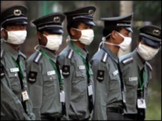 guardas de segurança chineses usam máscaras (Foto: AP)
