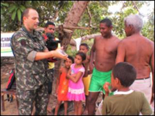 O major Carlo Endrigo Bueno Nunes faz demonstração sobre uso de preservativos a moradores da localidade de Santa Rosa, no Maranhão (foto: Alessandra Corrêa)