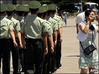 در جریان رژه نیروهای پلیس در میدان تیان آن من، یک توریست در حال عکسبرداری است