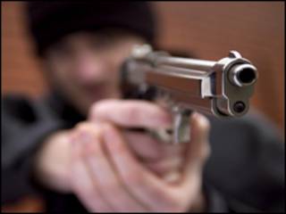 Joven apunta con una pistola.
