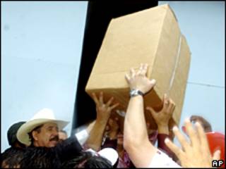 El presidente de Honduras, Manuel Zelaya, con sombrero, dirige a sus seguidores al recoger cajas en una base de la fuerza aérea en Tegucigalpa