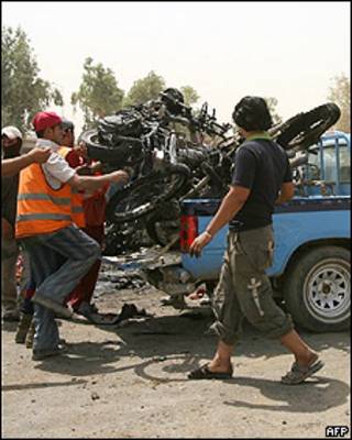 Hombre recoge motocicletas dañadas tras el atentado.