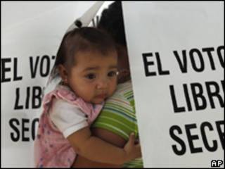 Una votante con una niña, en centro electoral en Hermosillo