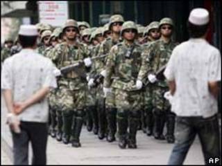 Soldados do Exército chinês fazem patrulha na cidade de Urumqi nesta segunda-feira (AP, 13/7)