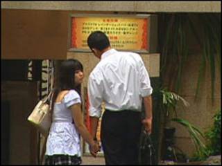 Casal japonês em frente a um dos hotéis