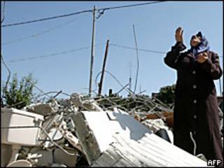 Una mujer mira al cielo entre escombros en Gaza