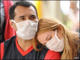 Casal usa máscaras em fila de espera do hospital Souza Aguiar, no Rio de Janeiro (AFP, 23 de julho)