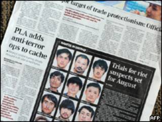 Jornal chinês com fotos de suspeitos de terem participado de onda de violência (AFP)