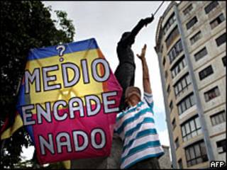 Manifestante y cartel en contra del cierre de radios