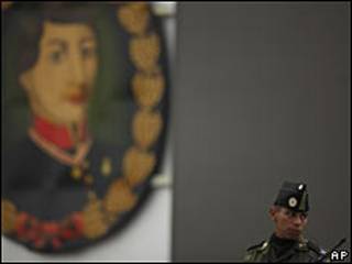 Un soldado parado próximo a una imagen del héroe mexicano Augustín Melgar.