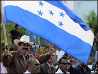 O presidente deposto de Honduras, Manuel Zelaya, acena a partidários reunidos em frente à Embaixada brasileira em Tegucigalpa