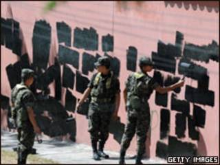 Soldados hondurenhos apagam pichação em muro perto da embaixada brasileira em Tegucigalpa