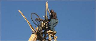 William Kamkwamba em cima de um dos moinhos construídos por ele