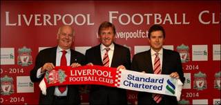 Representantes del Liverpool y Standard Chartered tras la firma del acuerdo