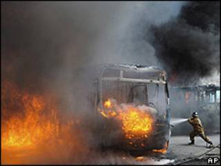 Bombeiro tenta apagar incêndio em ônibus queimado na Zona Norte do Rio