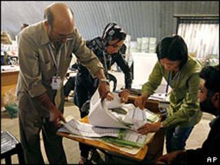 Funcionarios revisan urnas electorales.