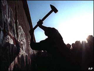 Imagem de arquivo mostra homem destruindo muro de Berlim com picareta, em 1989