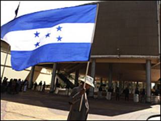 Hondurenho segura bandeira do país. Foto AP