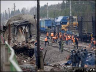 Investigadores y trabajadores de rescate se ven en medio de los restos del tren