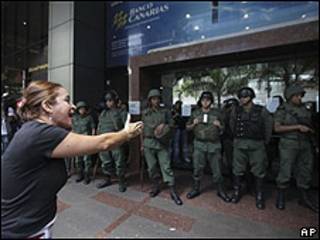 Empleada del Banco Canarias protesta frente a sede de la institución en Caracas